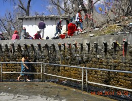 A lady taking bath at 108 holy tap in Muktinath 
